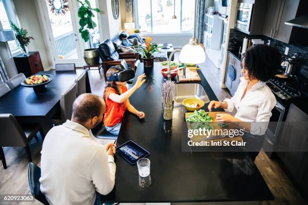 girl using virtual reality goggles in kitchen - 3d daughter stock pictures, royalty-free photos & images