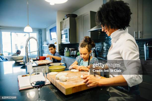 mother and children baking in kitchen - rollende keukens stockfoto's en -beelden