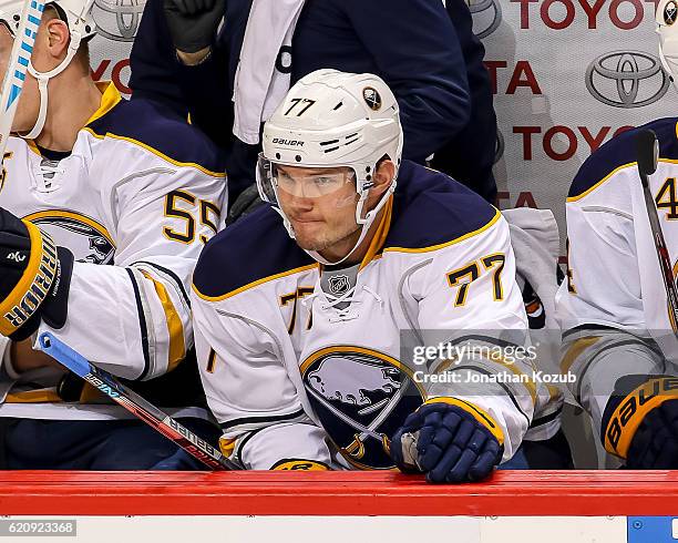Dmitry Kulikov of the Buffalo Sabres looks on from the bench during first period action against the Winnipeg Jets at the MTS Centre on October 30,...