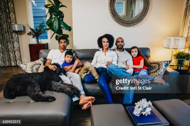 family watching television on sofa - african american watching tv stock pictures, royalty-free photos & images