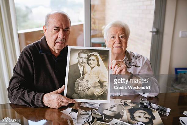 senior couple showing their wedding photo at home - wedding photos bildbanksfoton och bilder
