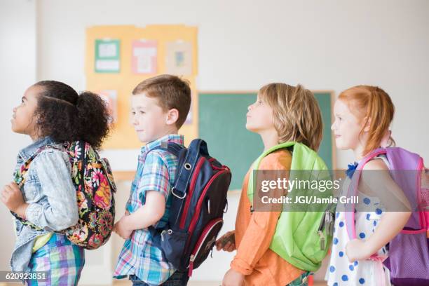 students wearing backpacks in classroom - first day of school bildbanksfoton och bilder