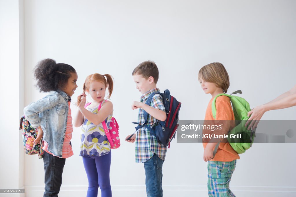 Students wearing backpacks in classroom