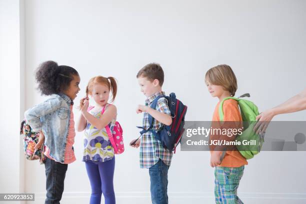 students wearing backpacks in classroom - fish out of water stock pictures, royalty-free photos & images