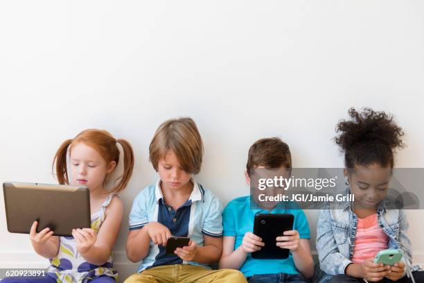 children using technology - boys mobile phone group stock pictures, royalty-free photos & images