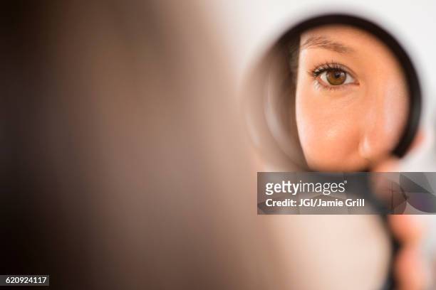 mixed race woman admiring herself in compact mirror - compact bildbanksfoton och bilder