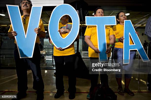 Attendees hold letters reading "Vote" in Spanish during a campaign event with Tim Kaine, 2016 Democratic vice presidential nominee, in Phoenix,...