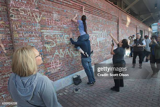 Chicago Cubs fans chalk messages on a wall outside Wrigley Field to the day after the Cubs defeated the Cleveland Indians to win the 2016 World...