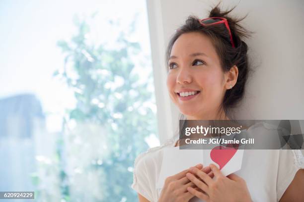 mixed race woman holding valentine card - ラブレター ストックフォトと画像