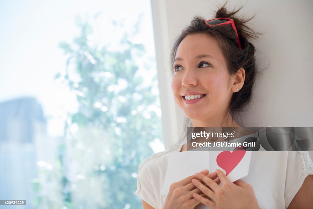 Mixed race woman holding Valentine card