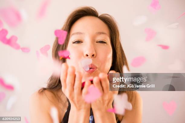 mixed race woman blowing confetti - blowing kiss stock pictures, royalty-free photos & images