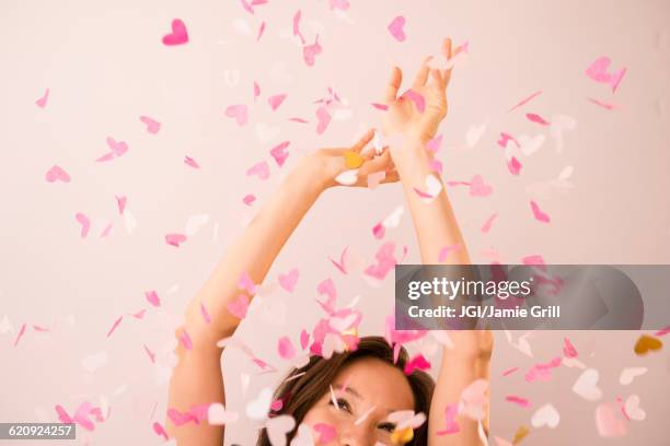 mixed race woman playing in confetti - blowing a kiss imagens e fotografias de stock