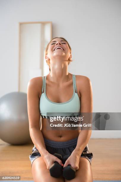 mixed race woman lifting weights in gym - woman in sports jersey stock pictures, royalty-free photos & images