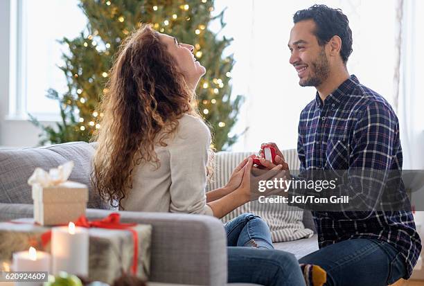 man proposing to girlfriend on sofa - man proposing indoor stock pictures, royalty-free photos & images