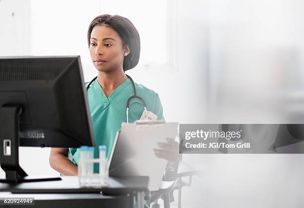 mixed race nurse smiling at computer - internship program stock pictures, royalty-free photos & images