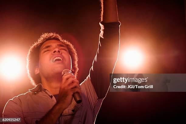 mixed race singer performing on stage - música gospel fotografías e imágenes de stock