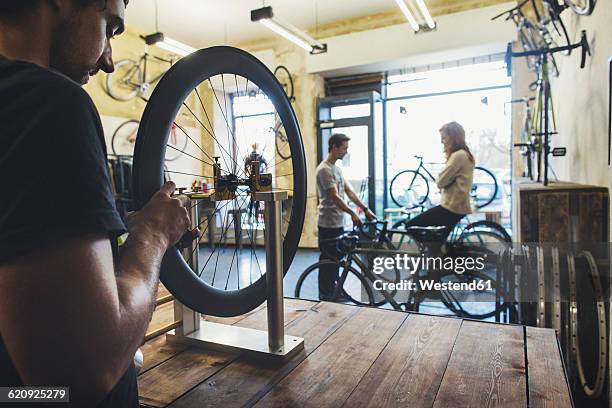 mechanic, salesman and client in a custom-made bicycle store - bicycle shop 個照片及圖片檔