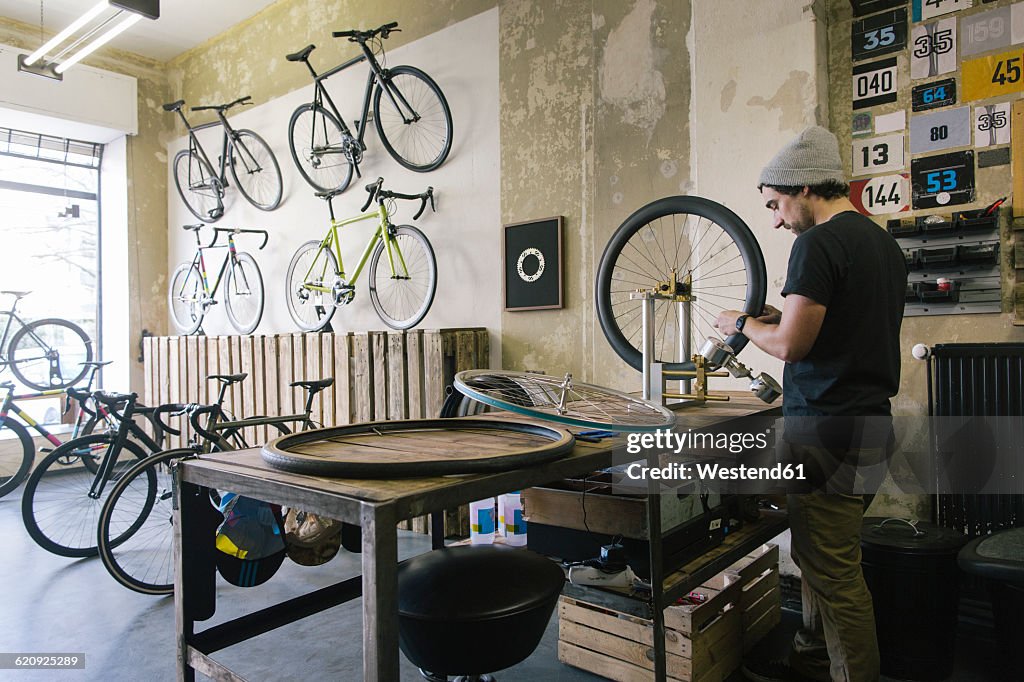 Mechanic working on tire in a custom-made bicycle store