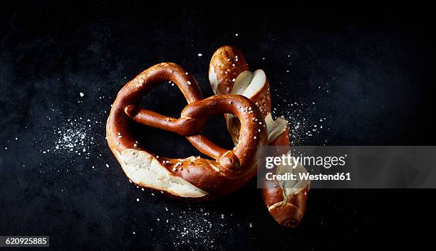 pretzel and pretzel roll on dark ground - brezel stock-fotos und bilder