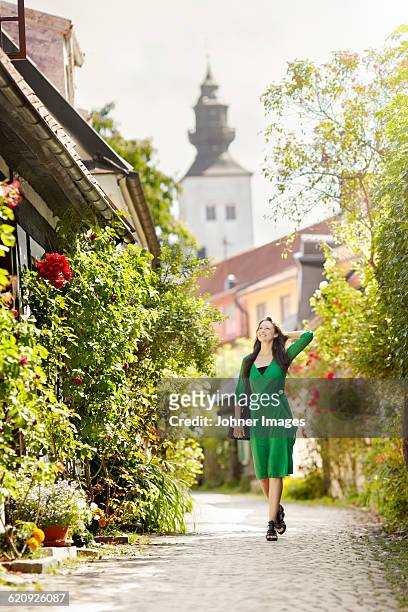 smiling woman walking through narrow street - gotland sweden stock pictures, royalty-free photos & images