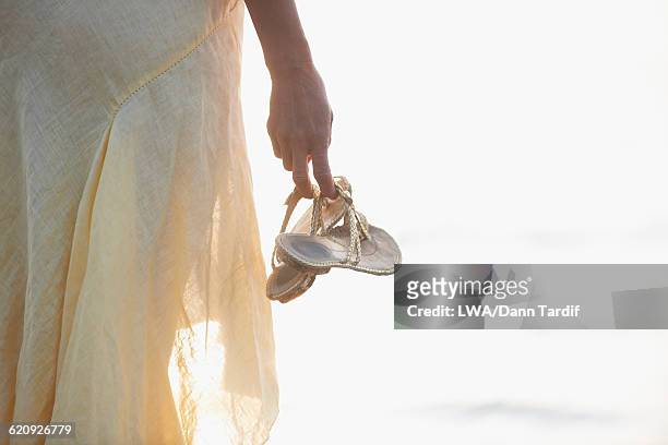 hispanic woman carrying sandals - sandales photos et images de collection