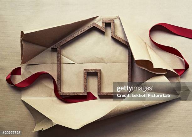 house shape in unwrapped gift - desenvolver fotografías e imágenes de stock