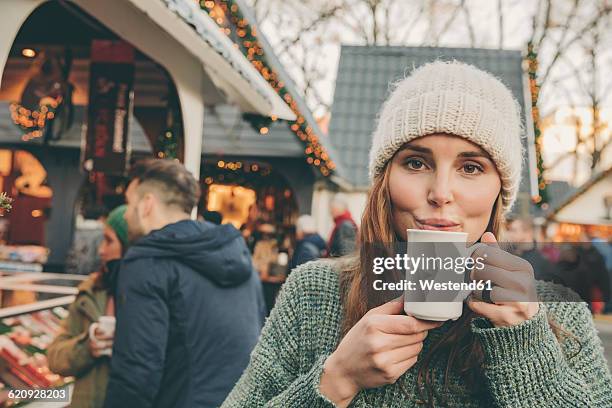 woman having a hot punch on the christmas market - glühwein stock-fotos und bilder