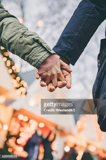 close-up of couple holding hands on the christmas market - lit cologne 2016 stock pictures, royalty-free photos & images