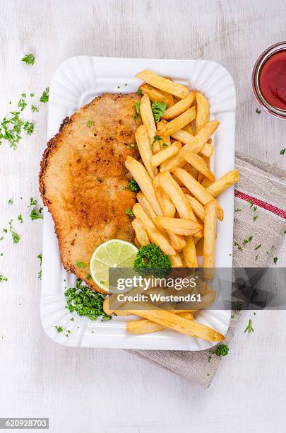 schnitzel with french fries and ketchup on paper plate - wiener schnitzel stock pictures, royalty-free photos & images