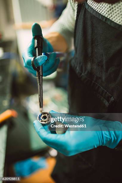 young mechanic greasing ball bearing, close up - ball bearing stock pictures, royalty-free photos & images