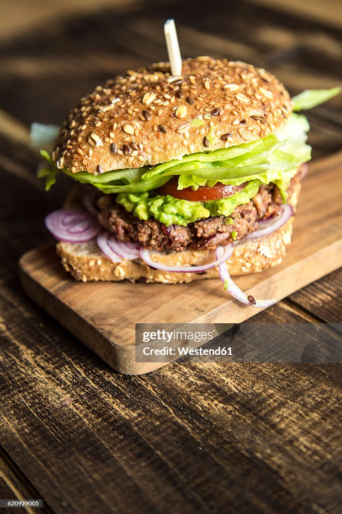 Vegetarian Burger with beetroot patty, avocado cream, salad and onions