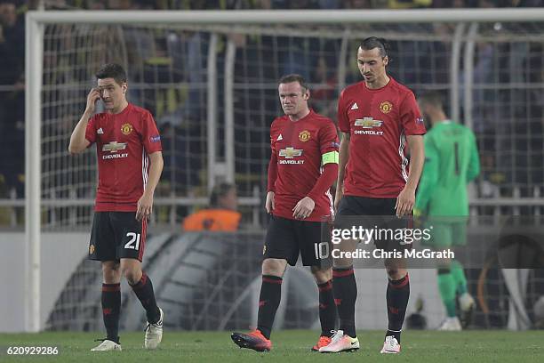 Manchester United players make their way back to the half way line after conceding their second goal during the UEFA Europa League Group A match...