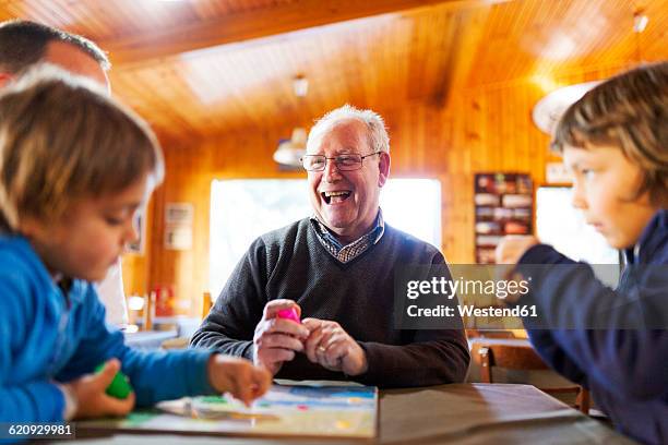 senior man playing with his grandsons - game night stock-fotos und bilder