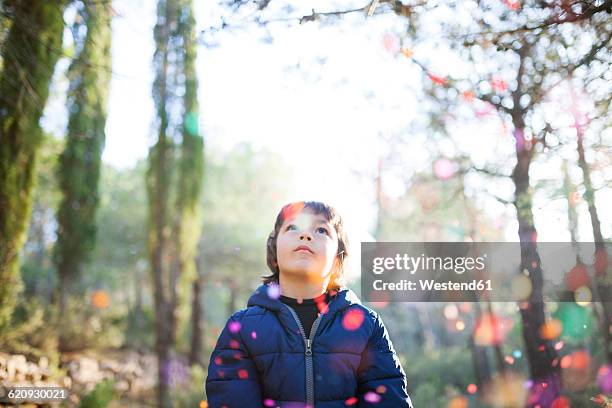 little boy looking up to falling confetti in the air - kid looking up to the sky imagens e fotografias de stock