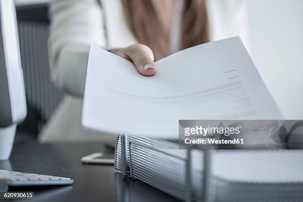 close-up of woman at desk handing over a document - personal perspective office stock pictures, royalty-free photos & images