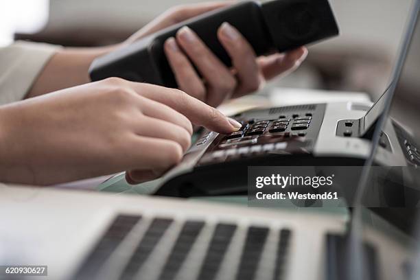 close-up of woman dialing a telephone number in office - phone receiver stock pictures, royalty-free photos & images