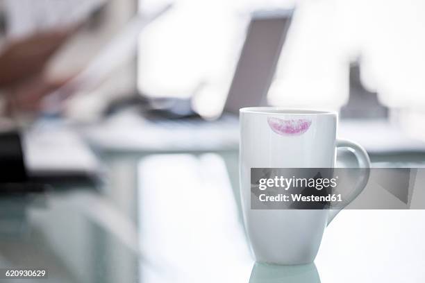 close-up of coffee cup on desk with red lipstick stain - lipstick stain stock pictures, royalty-free photos & images