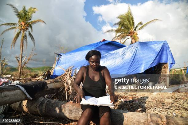 Antoinise sits close to her house damaged by Hurricane Matthew in the village of Labeyi, in the commune of Chardonnieres, in the southwestern Haiti,...