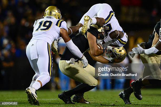 Quarterback Sefo Liufau of the Colorado Buffaloes is hit by defensive back Tahaan Goodman of the UCLA Bruins in the first quarter at Folsom Field on...