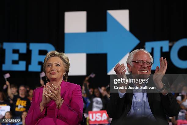 Democratic presidential nominee Hillary Clinton and U.S. Sen Bernie Sanders look on during a campaign rally at Coastal Credit Union Music Park at...