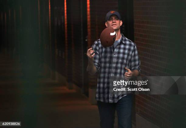 Theo Epstein, president of baseball operations for the Chicago Cubs, plays catch with a football with fans outside of Wrigley Field the day after the...