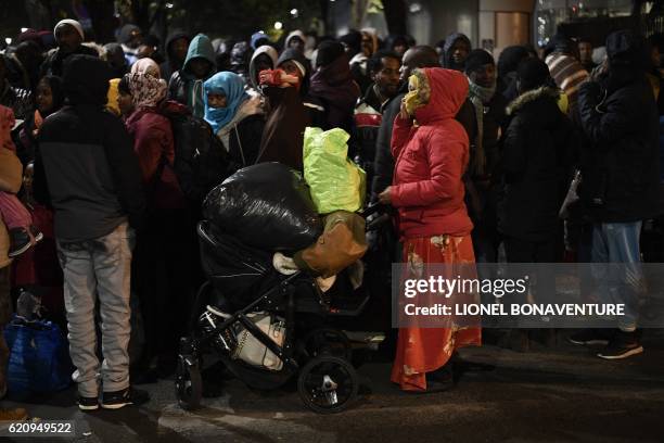 Migrants stand on the Avenue de Flandre during an evacuation of a makeshift camp in Paris on November 4 one of several camps sprouting up around the...