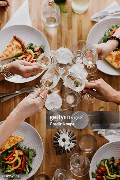 mature women having dinner party - friends toasting above table stock pictures, royalty-free photos & images