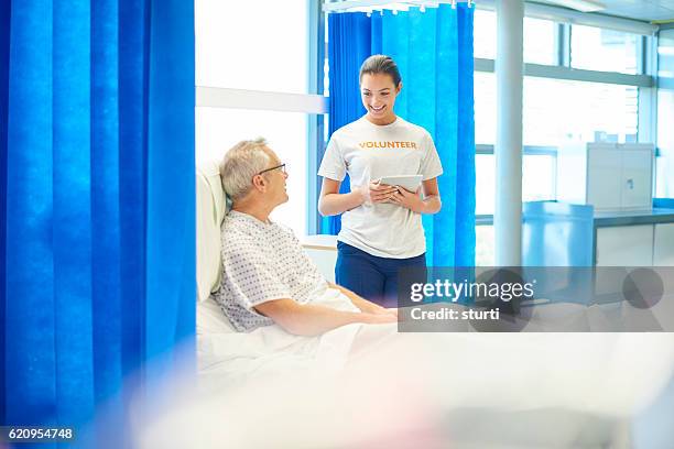 young hospital volunteer with patient - teenage hospital volunteer stock pictures, royalty-free photos & images