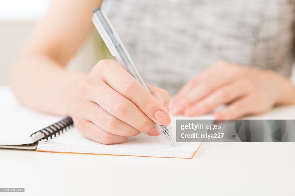 Japanese woman writing on a notebook