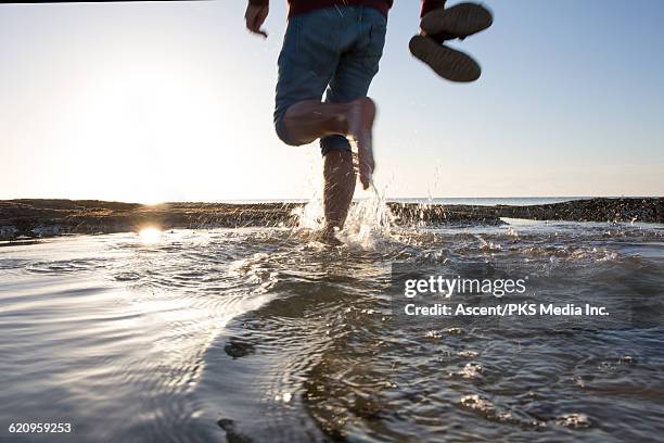 man walks through tidal pool at sunrise - feet moving stock pictures, royalty-free photos & images