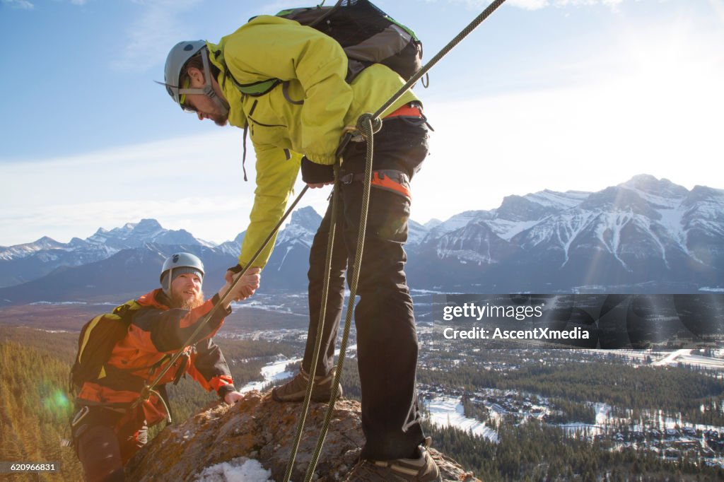 Bergsteiger bietet Teamkollegen eine helfende Hand