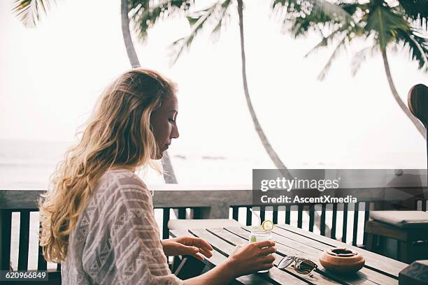 young woman relaxes at beachside cafe - wavy hair beach stock pictures, royalty-free photos & images