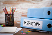 Instructions, Office Binder on Wooden Desk