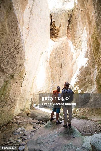 hikers explore rock canyon with climbing rope - republic of cyprus stock pictures, royalty-free photos & images